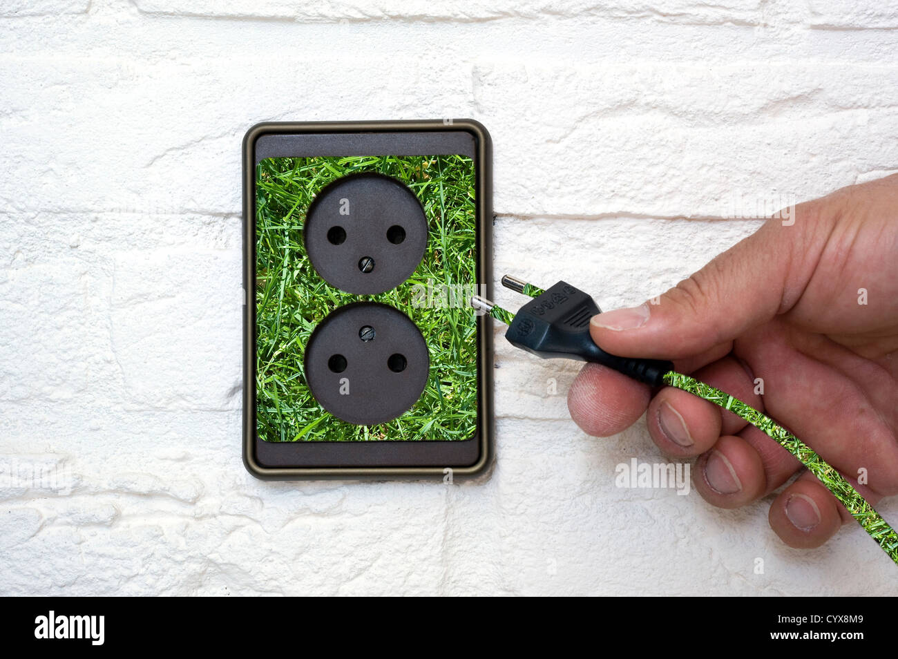 Green energy coming out of an outlet Stock Photo