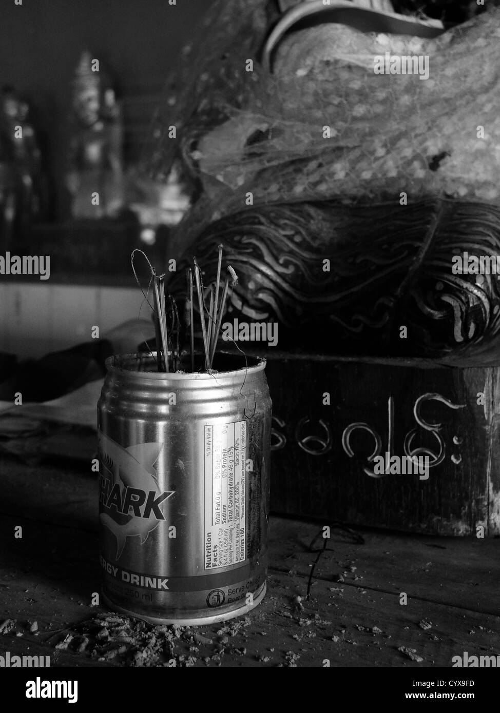 used incense sticks are seen in front of an image of Buddha in a discarded soft drinks can at Shwezigon pagoda, burma, Stock Photo
