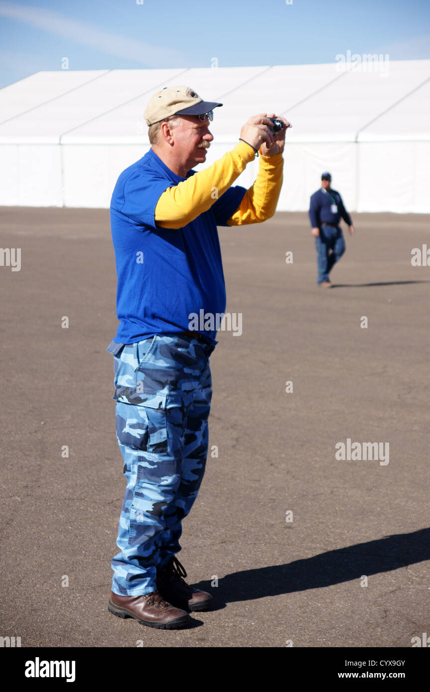 senior citizen aged man male taking photo with iphone cell phone android adult grownup mature human fellow Stock Photo