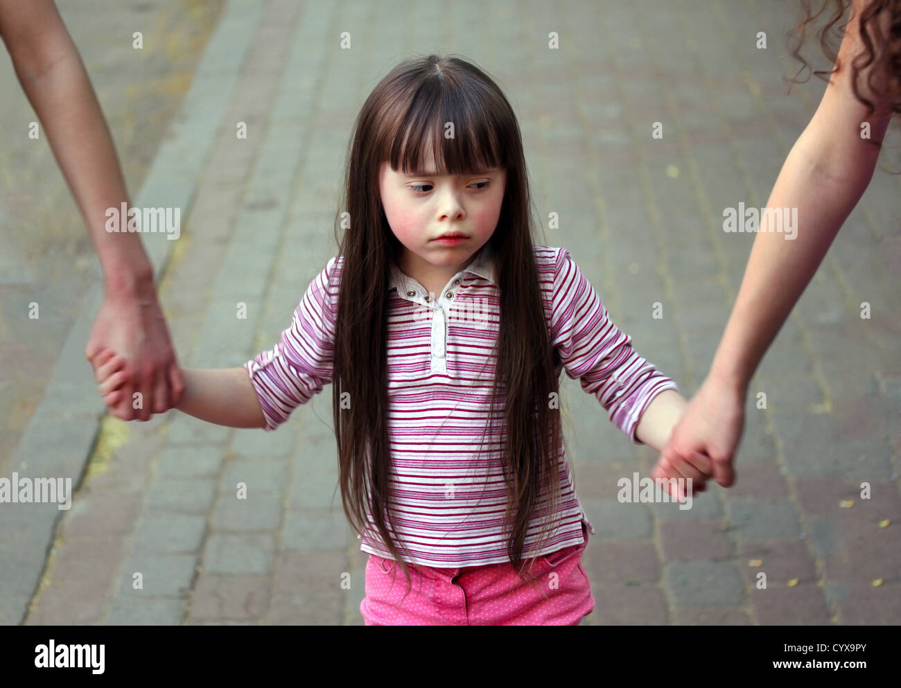 Girl holding arms of the sisters on a walk arm hires stock photography