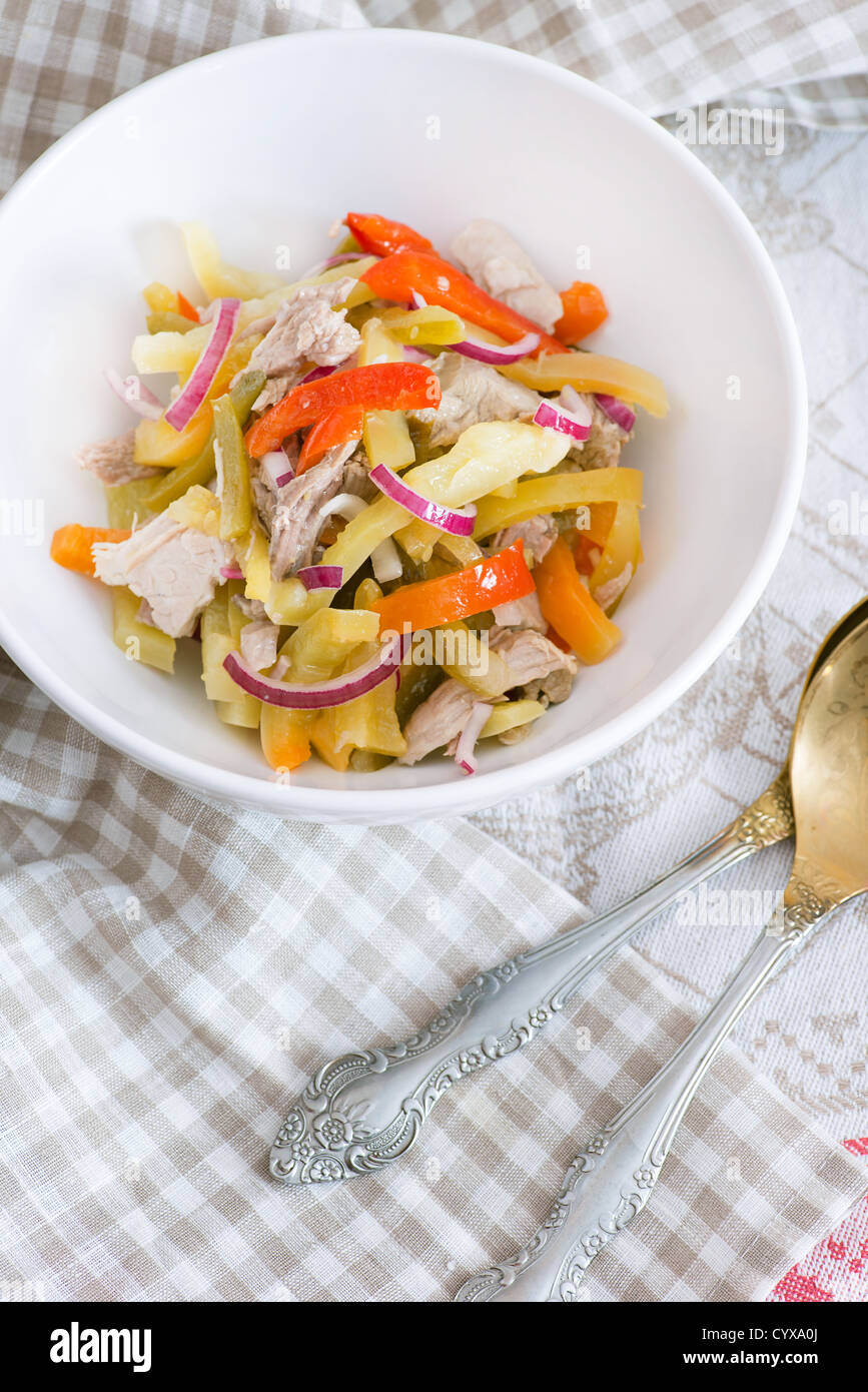 Portion of cold beef salad with pickled peppers in white bowl Stock Photo