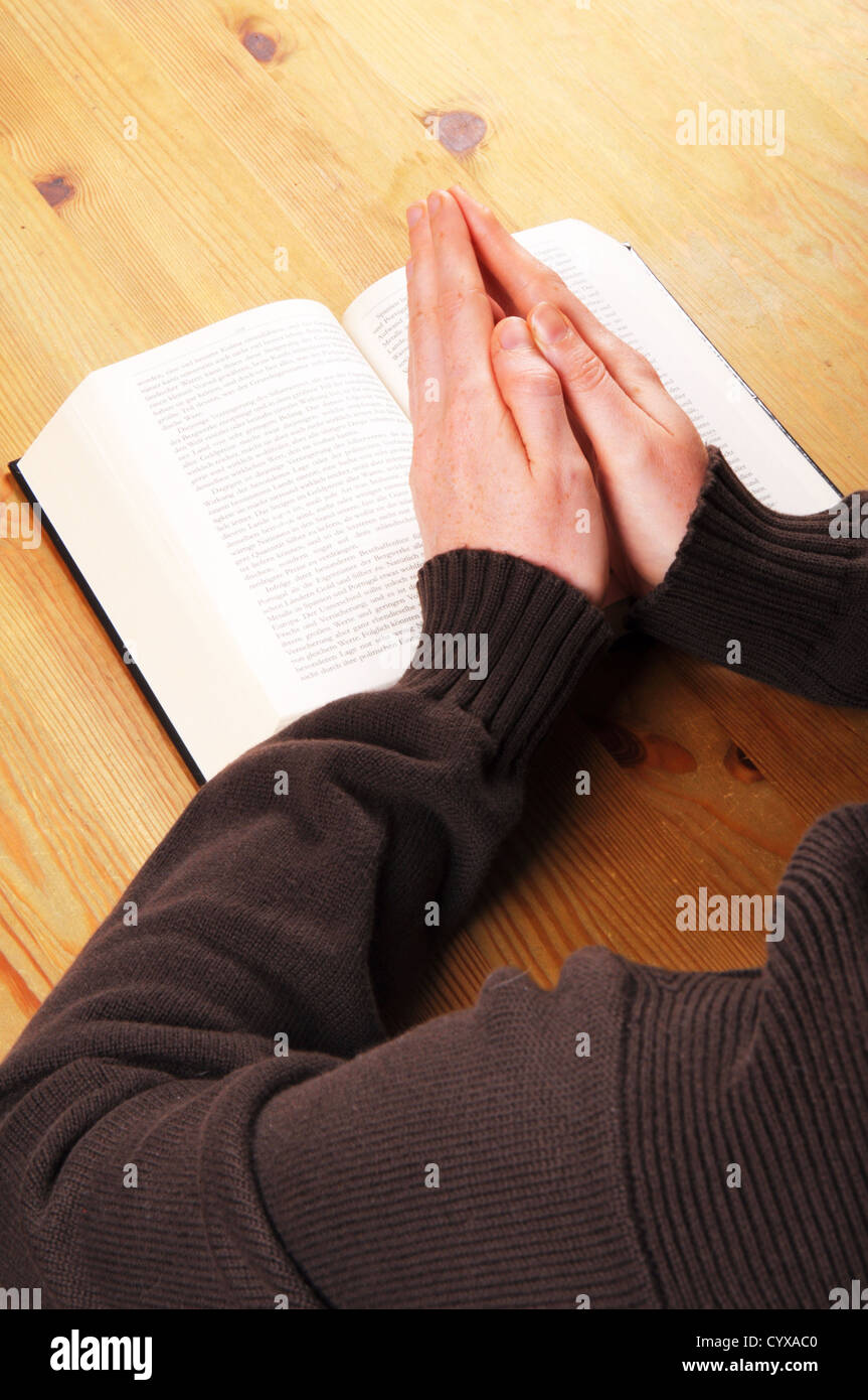 praying hands and book showing christian religion concept Stock Photo