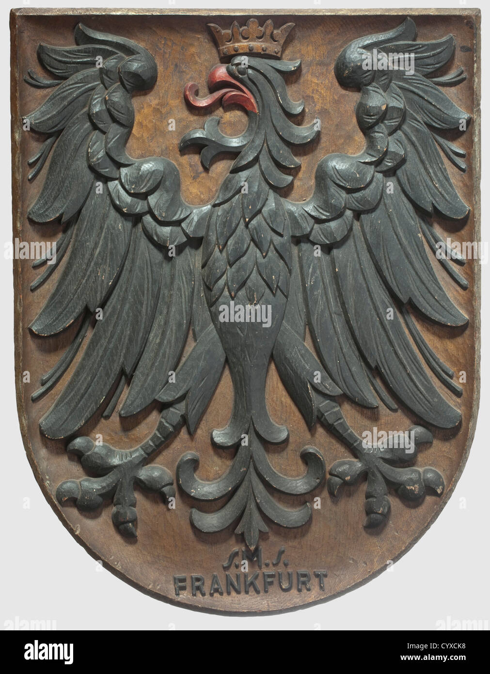 A German presentation shield from the S.M.S.Frankfurt,circa 1915 - 1918 Crowned eagle of the Frankfurt coat of arms,of beautifully carved oak wood,surmounting an inscription 'S.M.S.Frankfurt' in relief,set in black and gold bronze.Height 45 cm.The S.M.S.Frankfurt was a Wiesbaden class light cruiser.It took part in the battle of Jutland in 1916,the most important naval battle of World War I.In 1919 the fleet was ordered to be scuttled at Scapa Flow.The British,however,prevented this and transferred the ship to the United States as loot,where it w,Additional-Rights-Clearences-Not Available Stock Photo