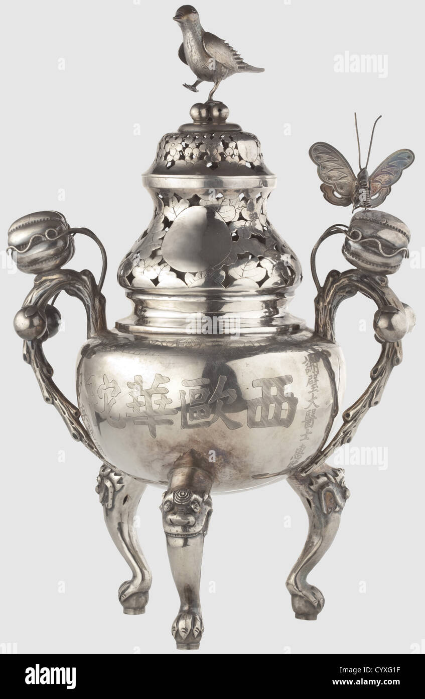 A silver scenter,China or Vietnam,circa 1900 Round body standing on three curved legs with dragon's heads.On either side a handle formed like a branch decorated with three-dimensional fruits and a moveable butterfly sitting on one handle.Opposite butterfly missing.The neck with openwork leaf decoration,the cap with floral decoration and an affixed three-dimensional bird.On the obverse side the talismanic Chinese inscription 'it may last 2000 years...' In the bottom Chinese punchmarks.Height 36.5 cm,weight 787 g.Allegedly a personal present by the Viet,Additional-Rights-Clearences-Not Available Stock Photo