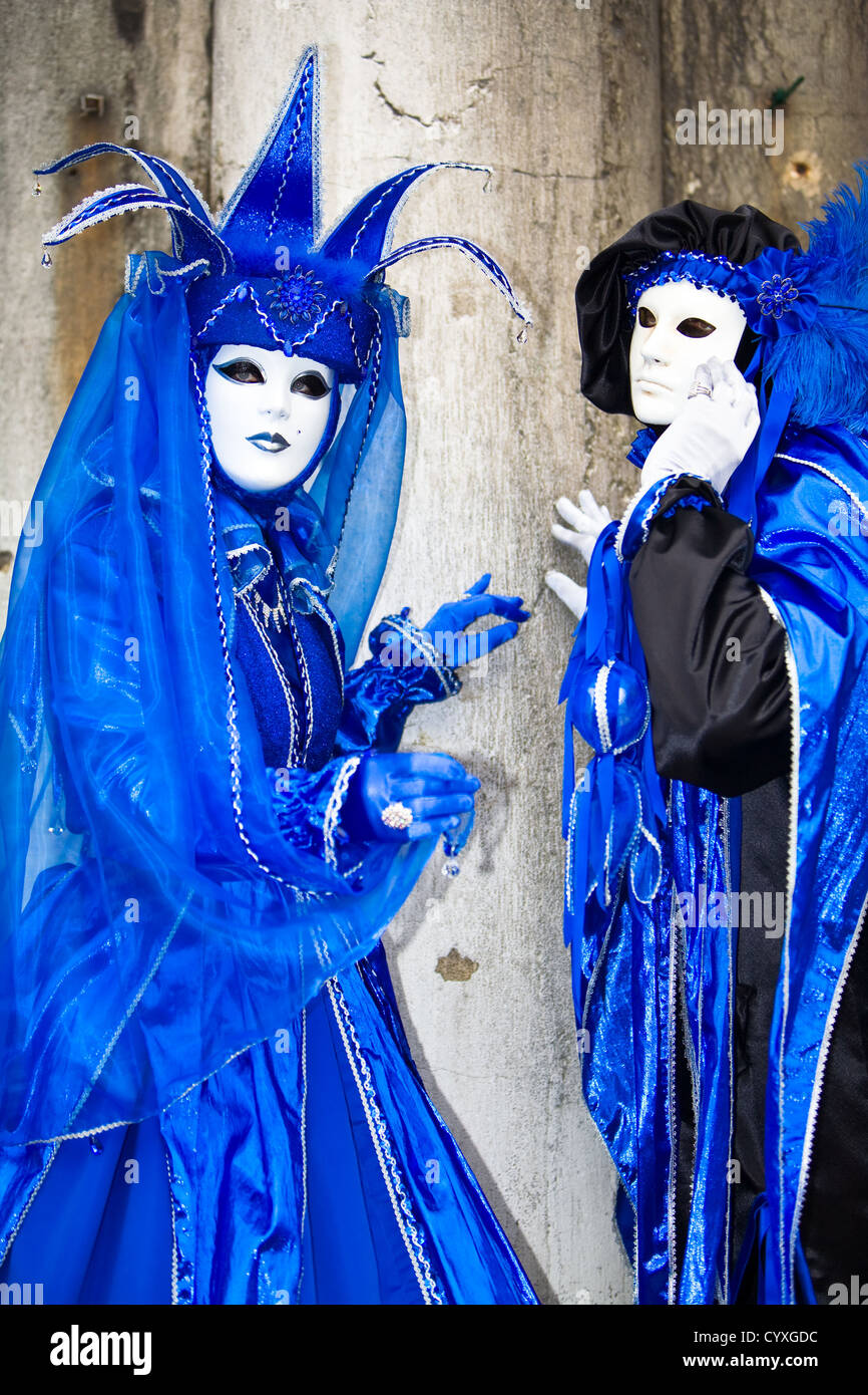 Two people in blue and black costumes at the Venice Carnival Stock Photo