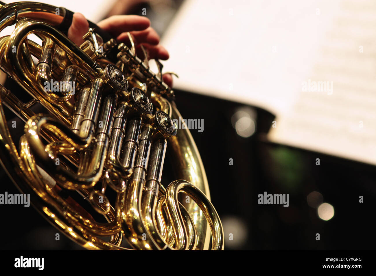Detail of hand playing notes on a french horn hires stock photography