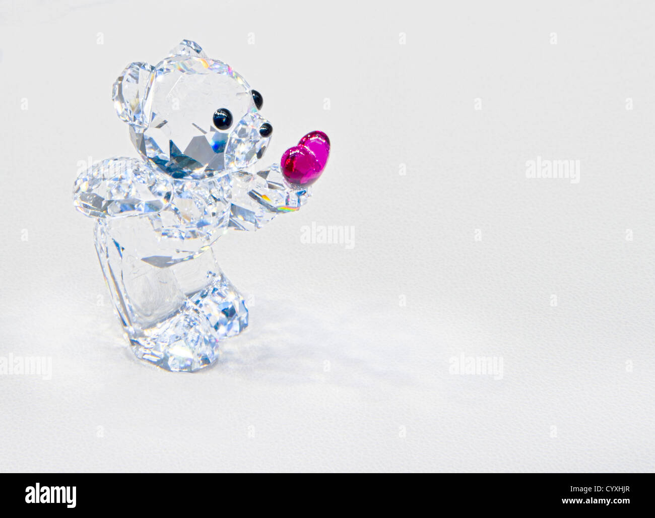 Crystal teddy bear with pinkish heart sending love. Copy space. Stock Photo