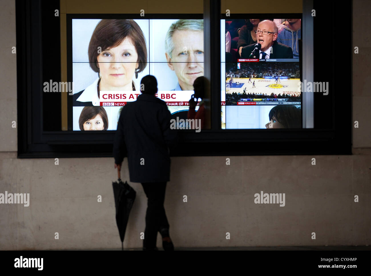 BBC Portland Place, London, UK. 12.11.2012 A man stops to watch the news headlines outside  the BBC News Corporations Broadcasting House in Portland Place as BBC announces the head of news Helen Boaden and her deputy Steve Mitchell have both resigned today. Stock Photo