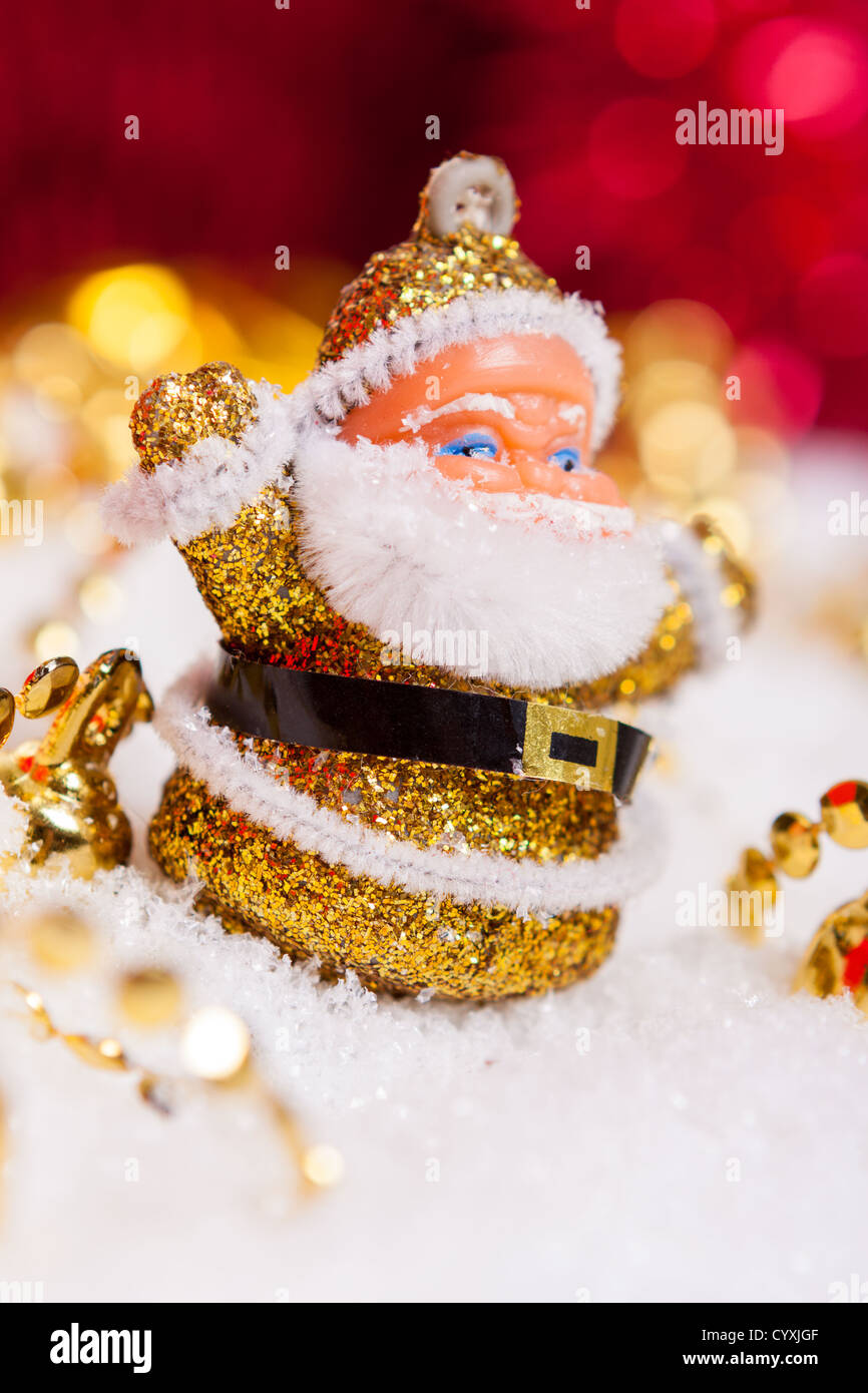 Santa Claus figurine wearing golden outfit with Christmas decorations ...