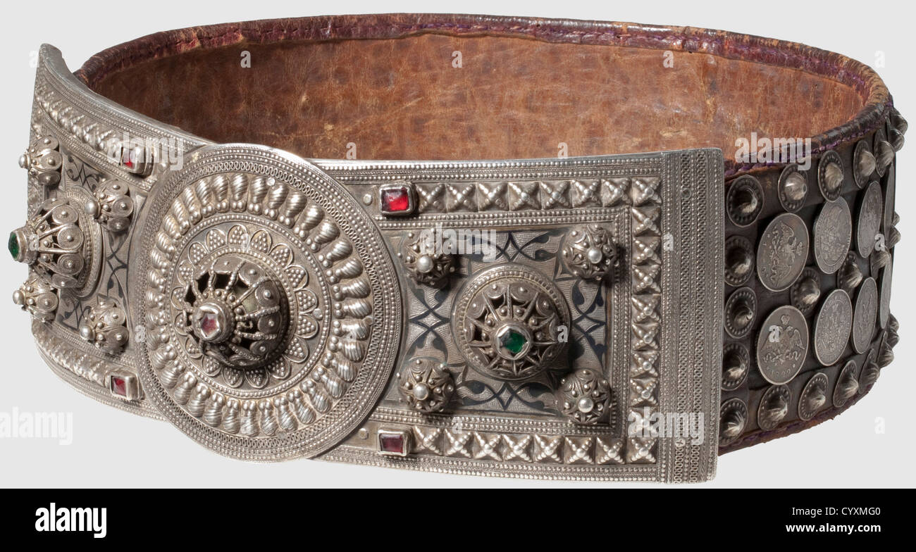 A Caucasian/ Russian ceremonial belt with silver ornamentation, dated 1861 Two piece silver belt buckle with niello, set with filigree and glass gems, and with the maker's name and date '1278' (=1861) in niello. Heavy leather belt elaborately decorated on the outside with silver rivets and 38 Russian silver coins. Length 88 cm, historic, historical, 19th century, Ottoman Empire, object, objects, stills, clipping, clippings, cut out, cut-out, cut-outs, jewellery, jewelry, Additional-Rights-Clearences-Not Available Stock Photo