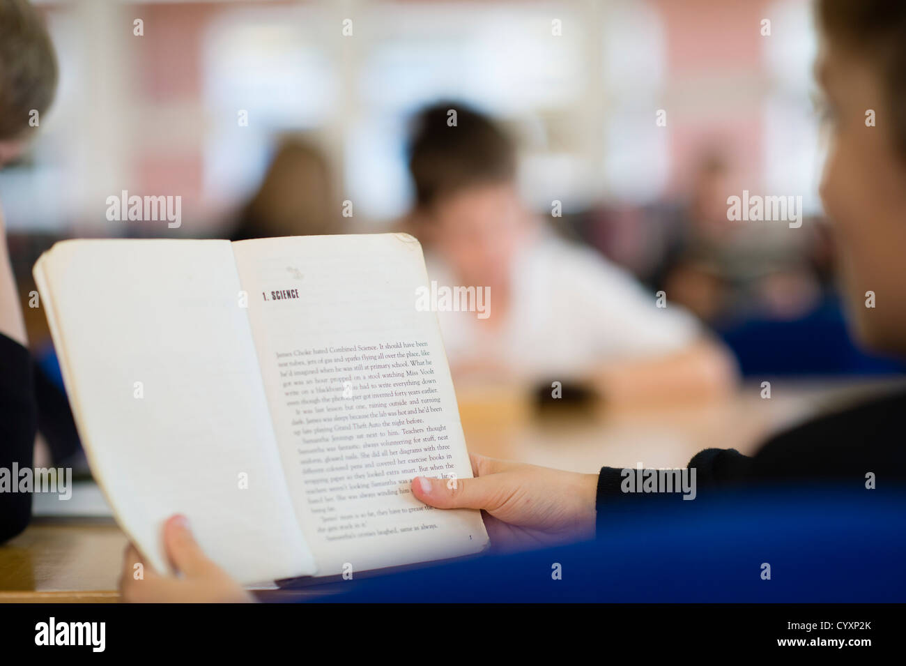 Pupils students reading book in the library at a secondary comprehensive school, Wales UK Stock Photo