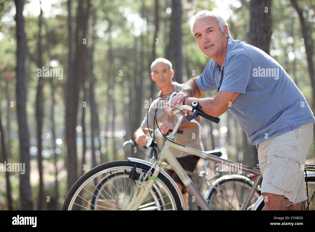 two seniors riding bikes in the park Stock Photo - Alamy