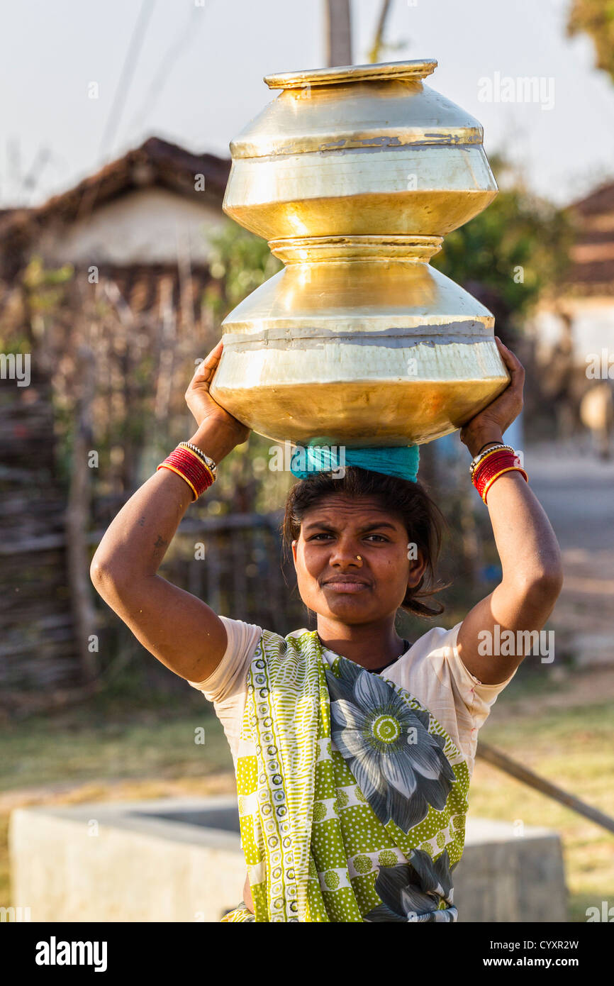 India, Madhya Pradesh, Woman carrying big water pots on her head Stock Photo