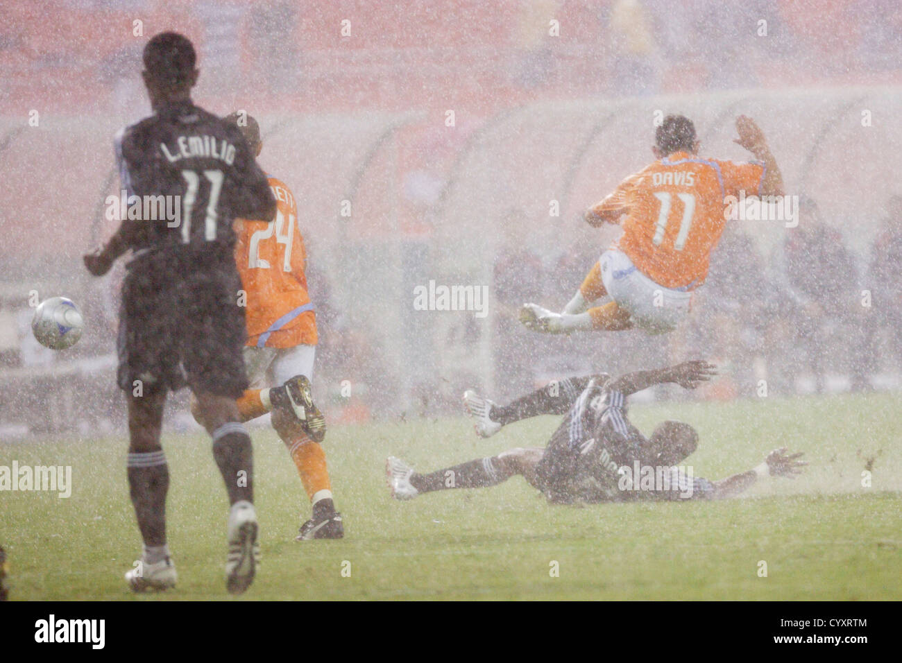Gonzalo Martinez of DC United tackles Brad Davis of the Houston Dynamo in torrential rain during a Major League Soccer match. Stock Photo
