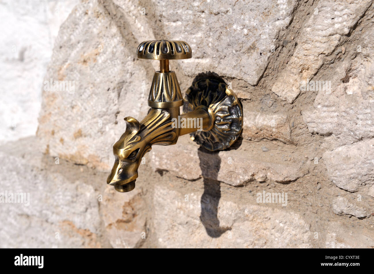 Decorative outdoor water tap on stone wall Stock Photo