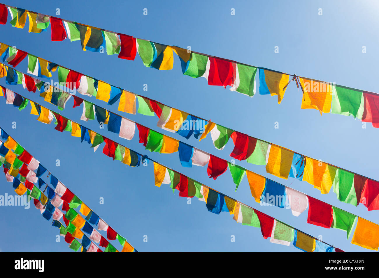 Buddhist tibetan prayer flags waving in the wind against blue sky Stock Photo