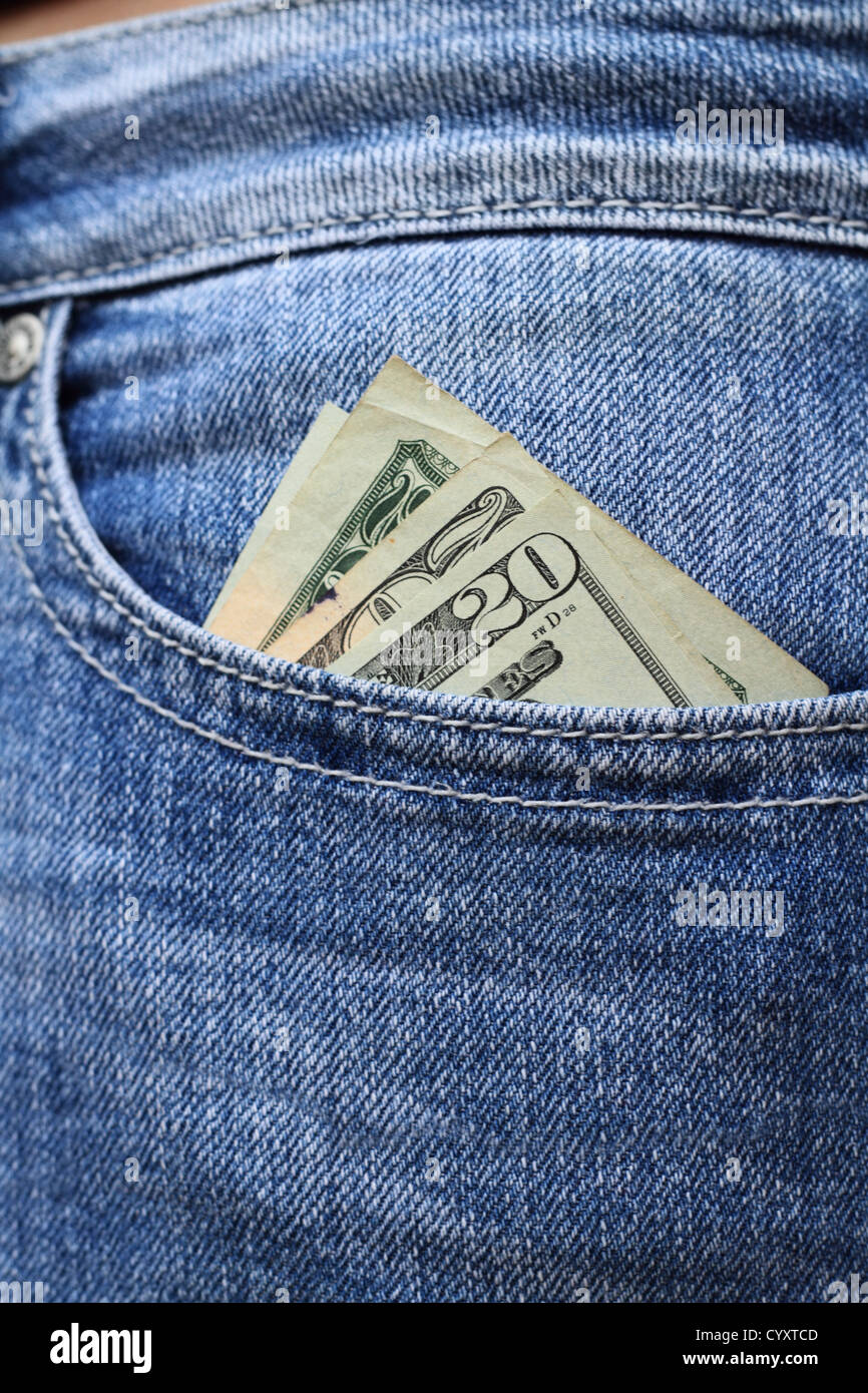 Twenty dollar bills tucked into a woman's jeans hip pocket. Shallow dof with selective focus on cash. Stock Photo