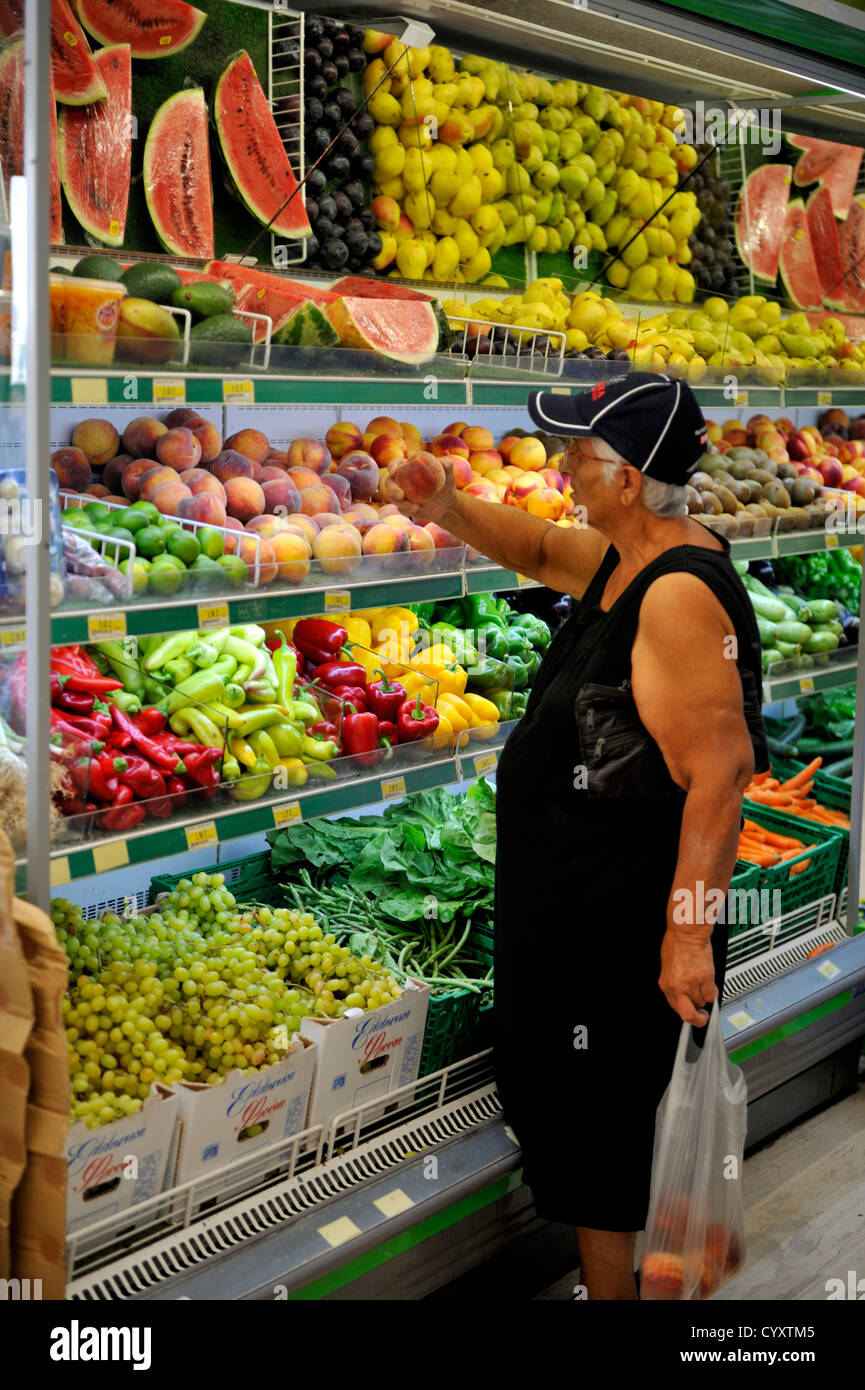 Older Greek woman shopping for fruit and vegetables in supermarket, Kos island Greece Stock Photo