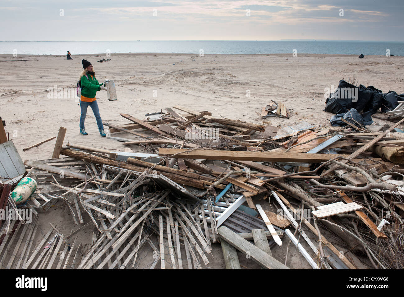 Volunteers clean up debris and sand deposited by Hurricane Sandy from