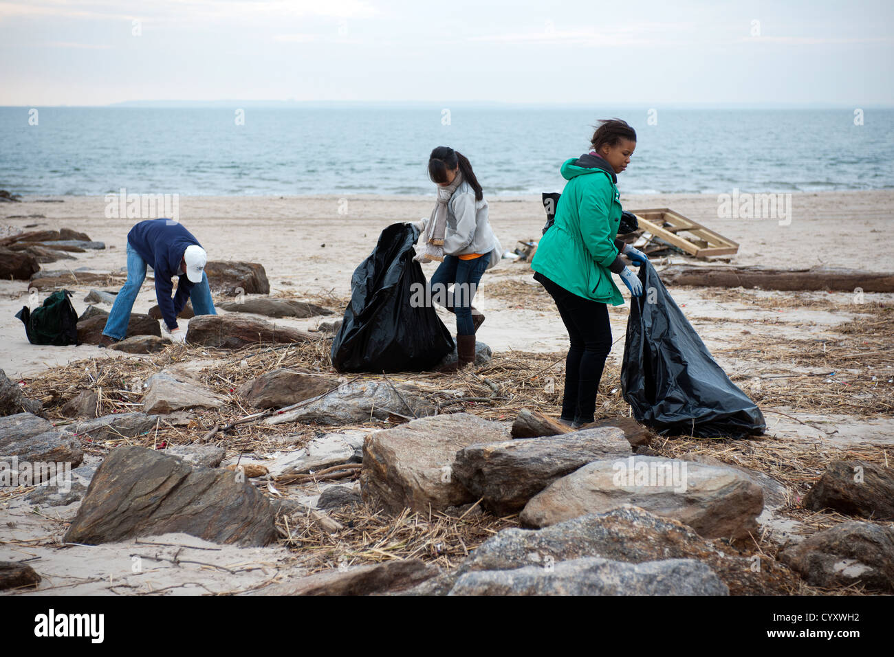 Volunteers clean up debris and sand deposited by Hurricane Sandy from