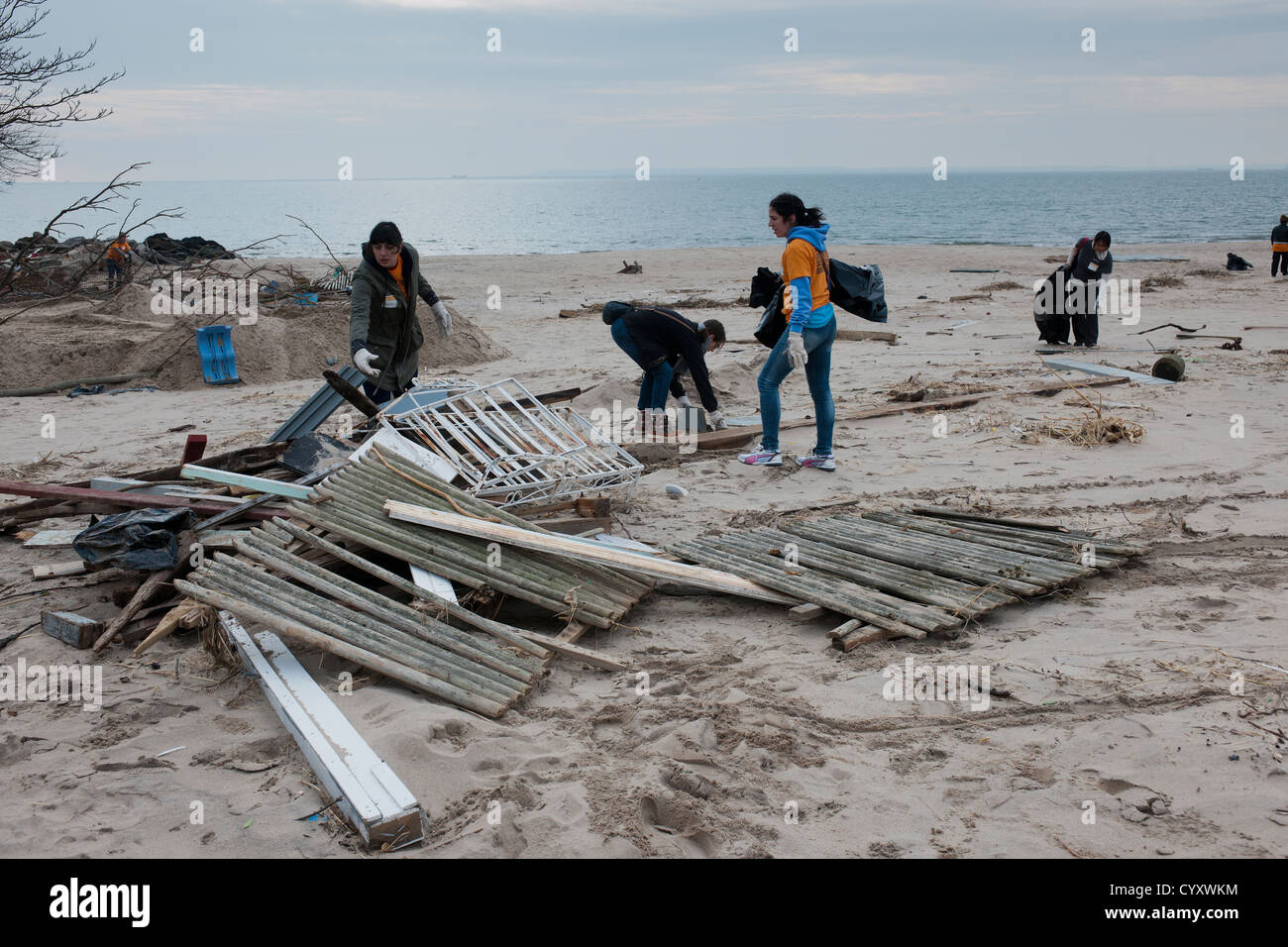 Volunteers clean up debris and sand deposited by Hurricane Sandy from