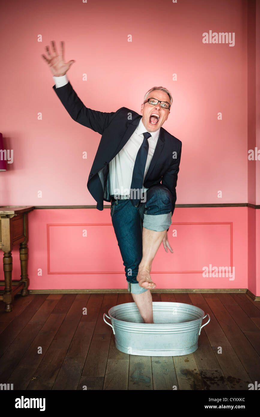 Germany, Stuttgart, Businessman standing in bathtub and shouting Stock Photo