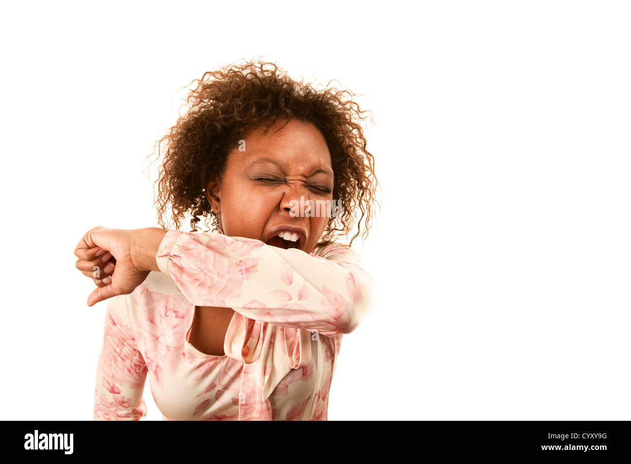 Young woman sneezing into her sleeve to prevent disease spread Stock Photo