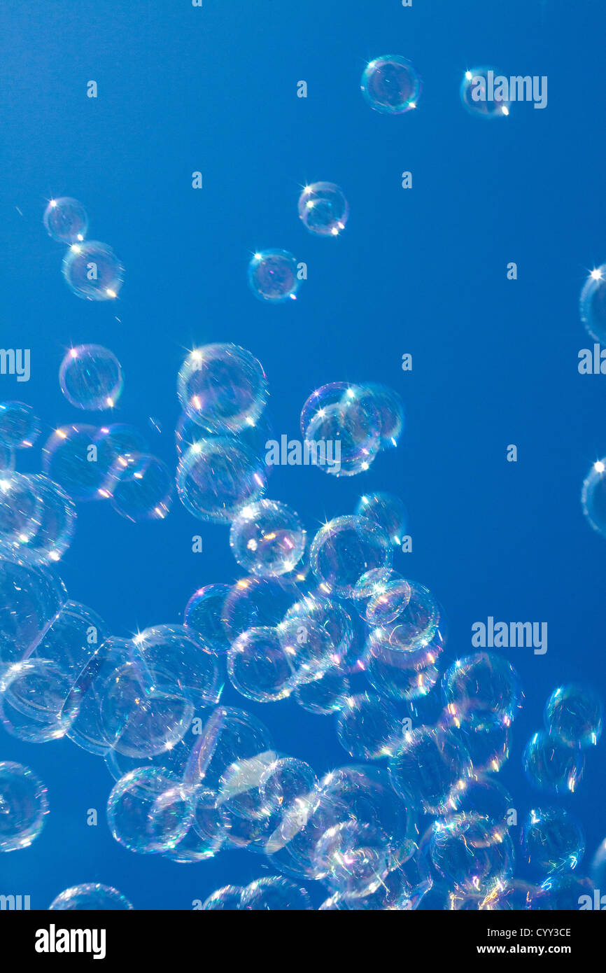 Soap bubbles. Air is blowing through a ring, covered with soapy water. Made with a children toy, a soap bubble machine. Stock Photo