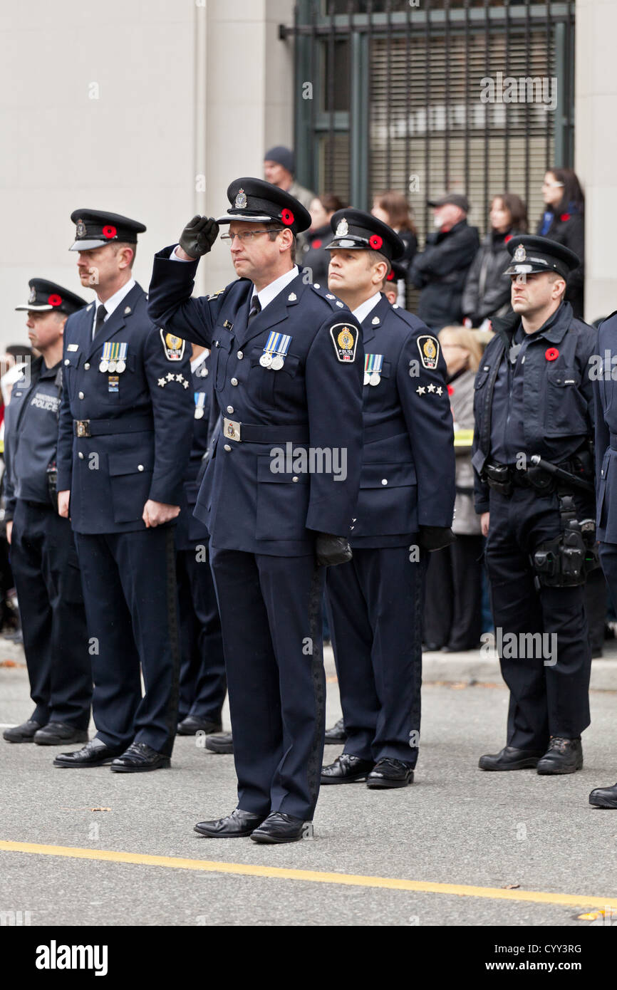 Police officers ware poppy's and stand on guard on Remembrance Day at the Cenotaph in Vancouver's Victory Square. Stock Photo