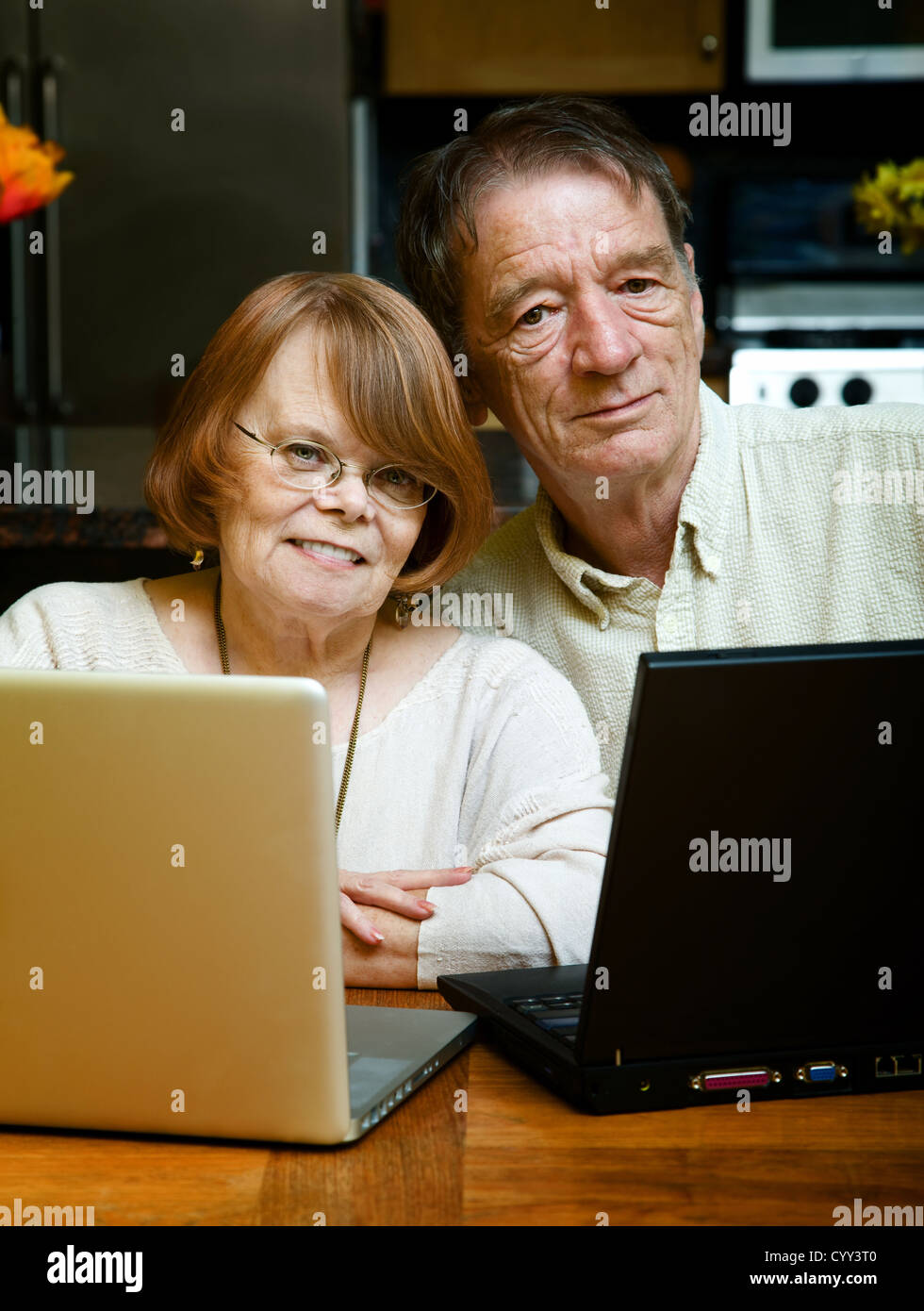 Senior couple using two laptop computers at home Stock Photo
