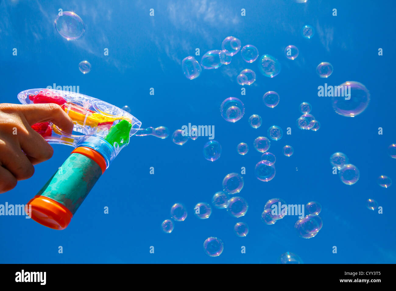 Soap bubbles. Air is blowing through a ring, covered with soapy water. Made with a children toy, a soap bubble machine. Stock Photo