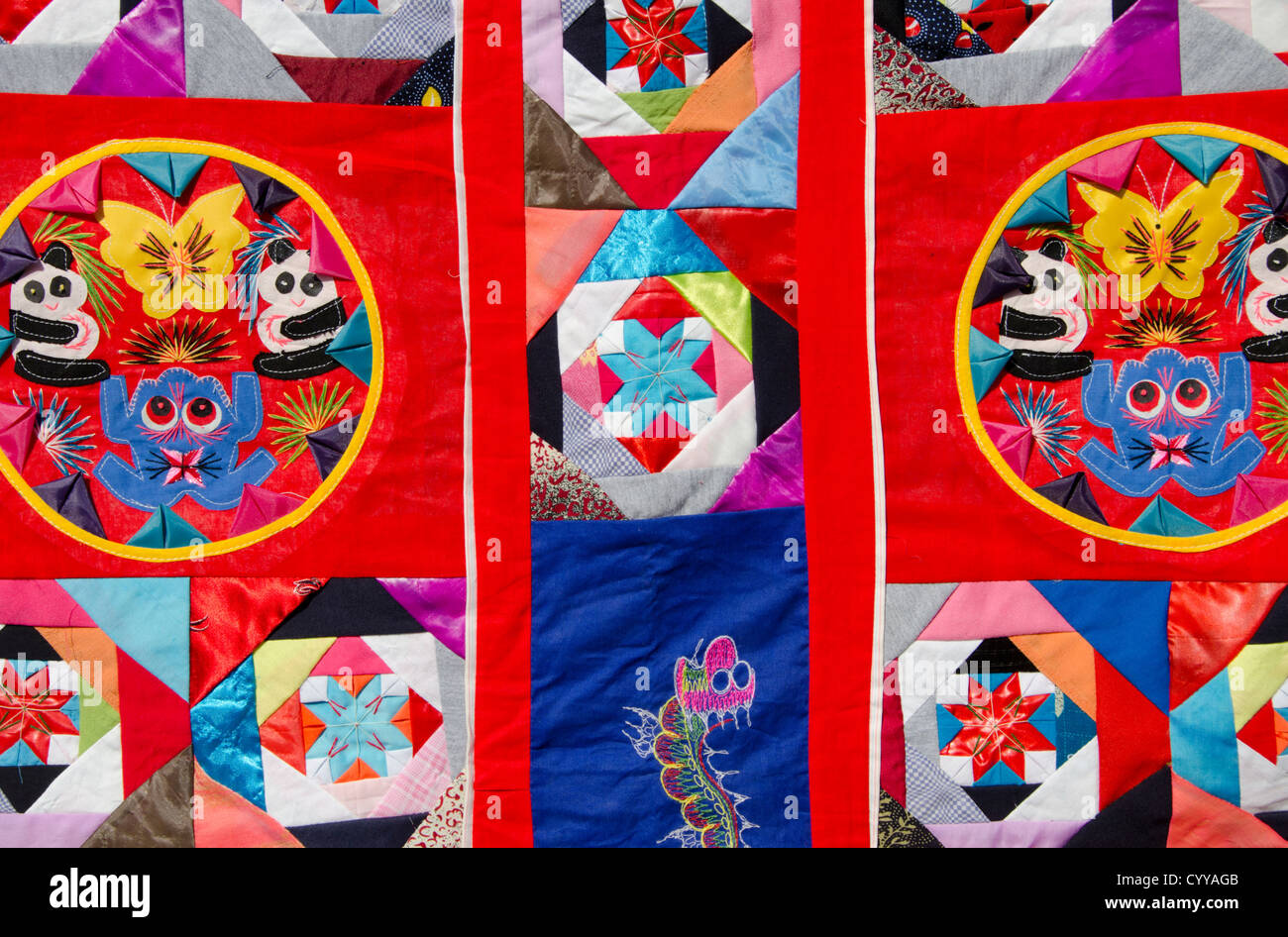 China, Beijing. Traditional Chinese handicrafts. Colorful Chinese embroidery quilt with panda bear, dragon and frog design. Stock Photo