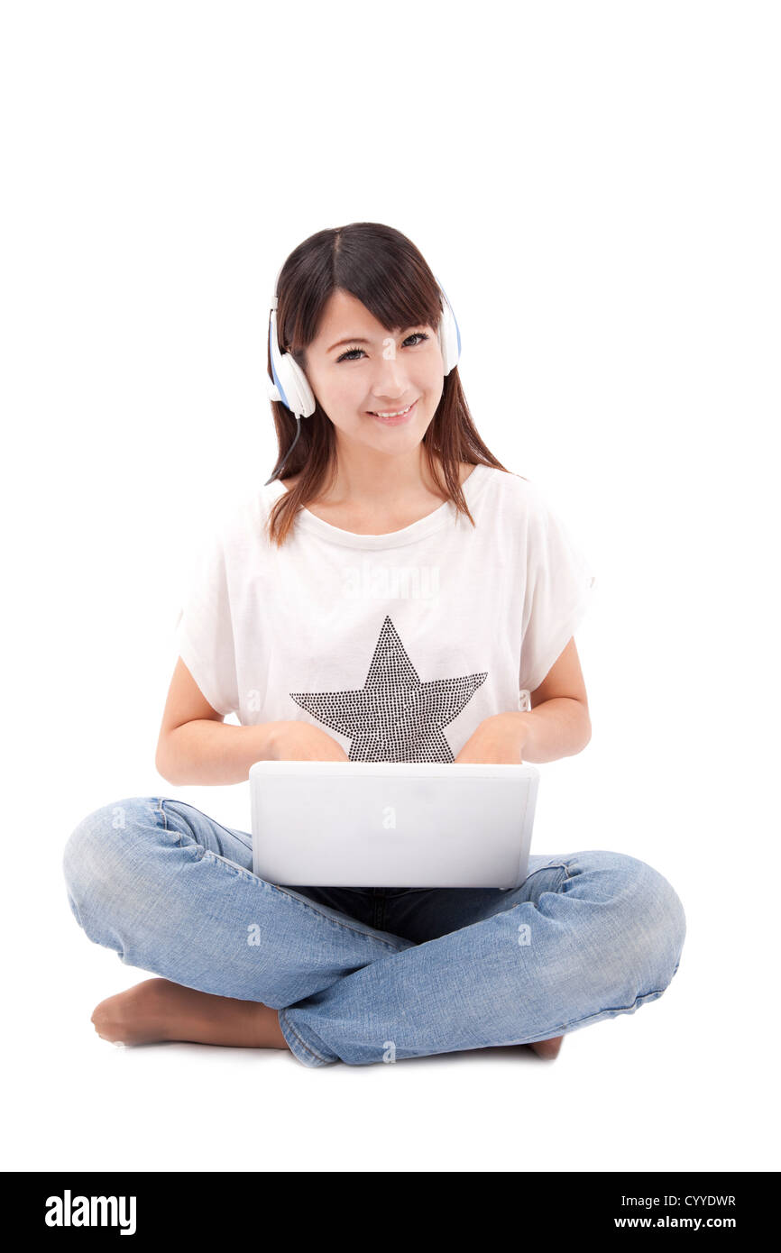 Young  woman working on laptop and listening music Stock Photo