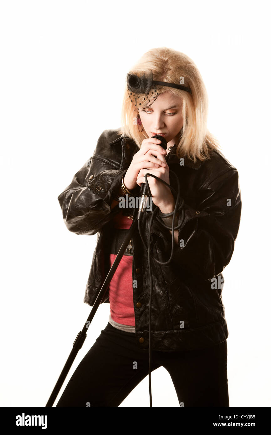 Pretty young female blonde singer or comedian with microphone Stock Photo
