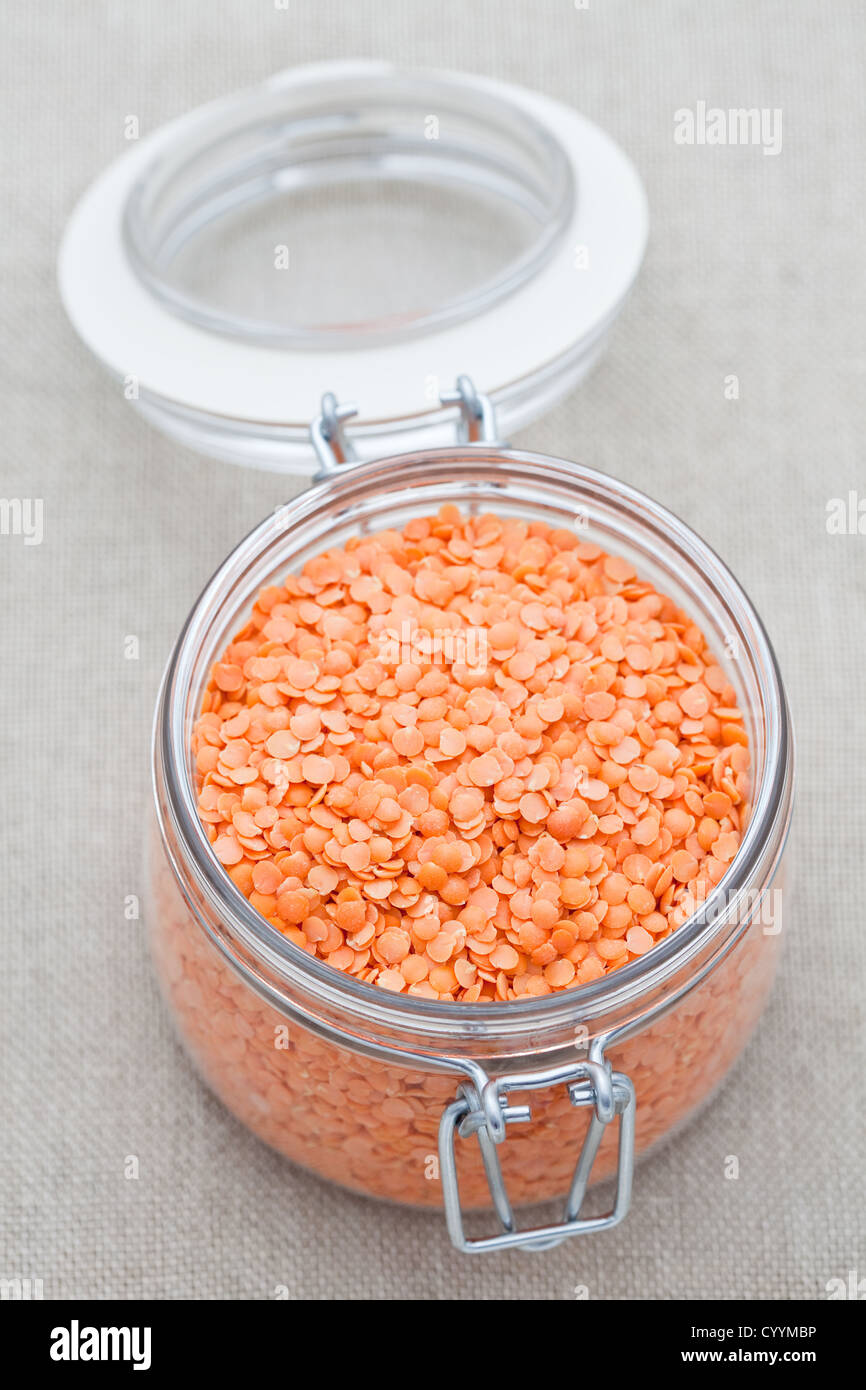 Jar of red split lentils on a hessian background Stock Photo