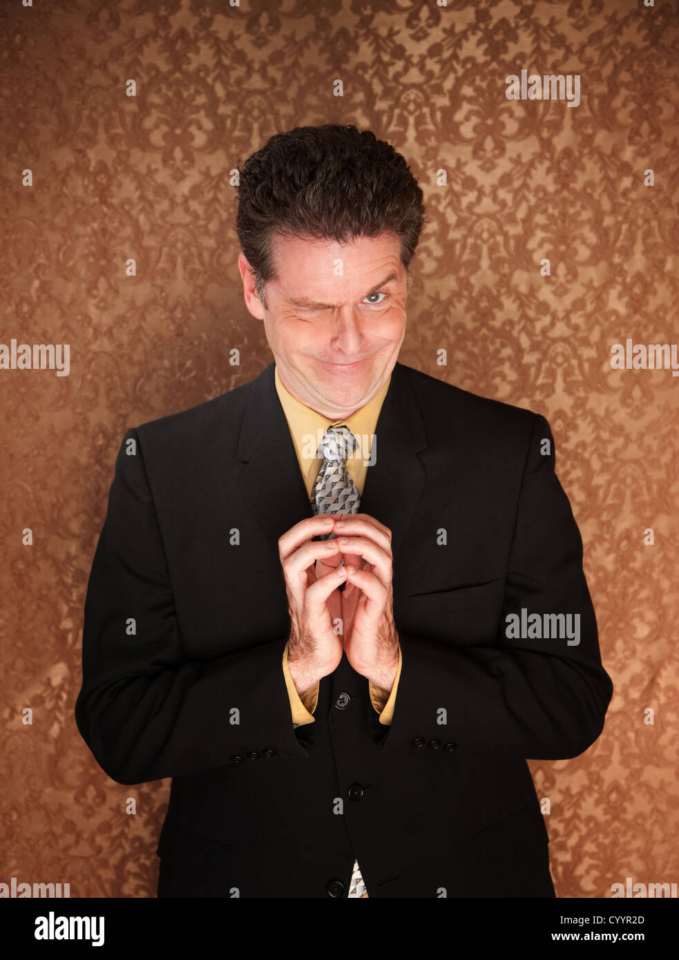 A tricky businessman winking and thinking of a plan Stock Photo