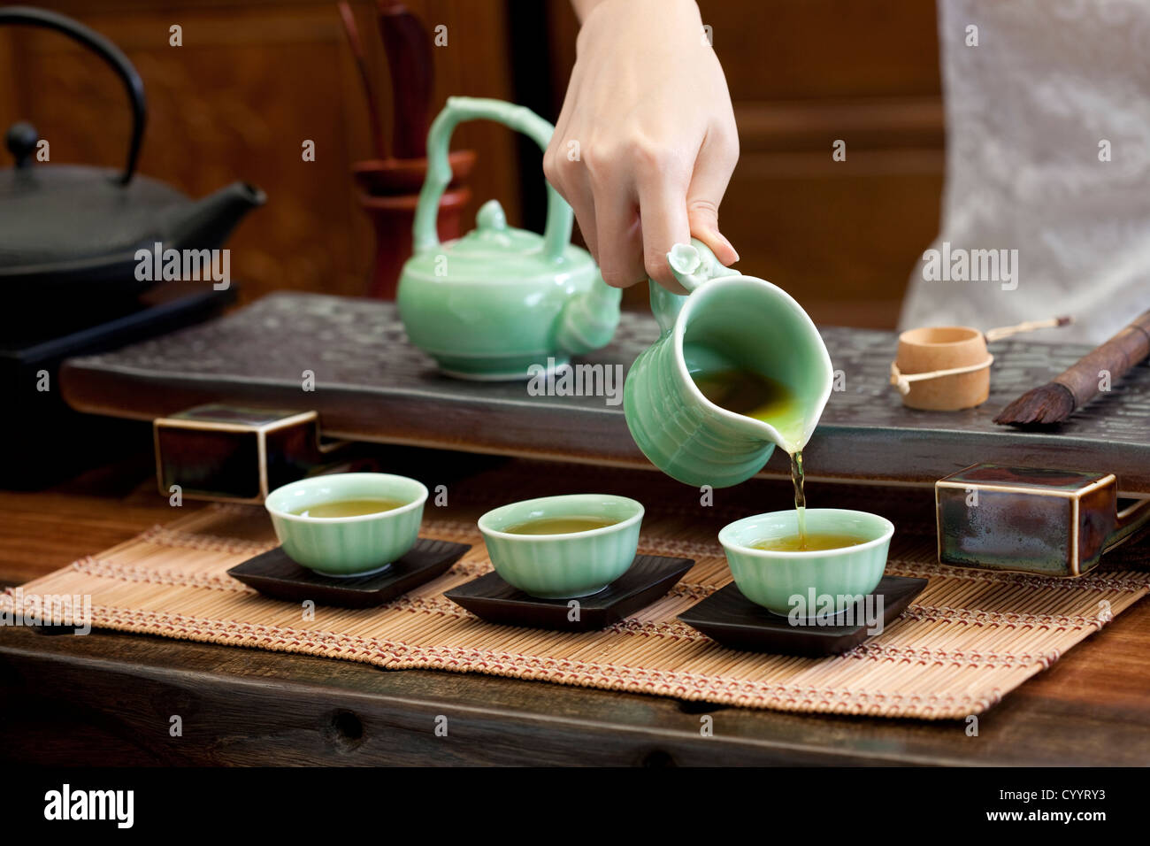 Female hand pouring tea into tea cups Stock Photo Alamy