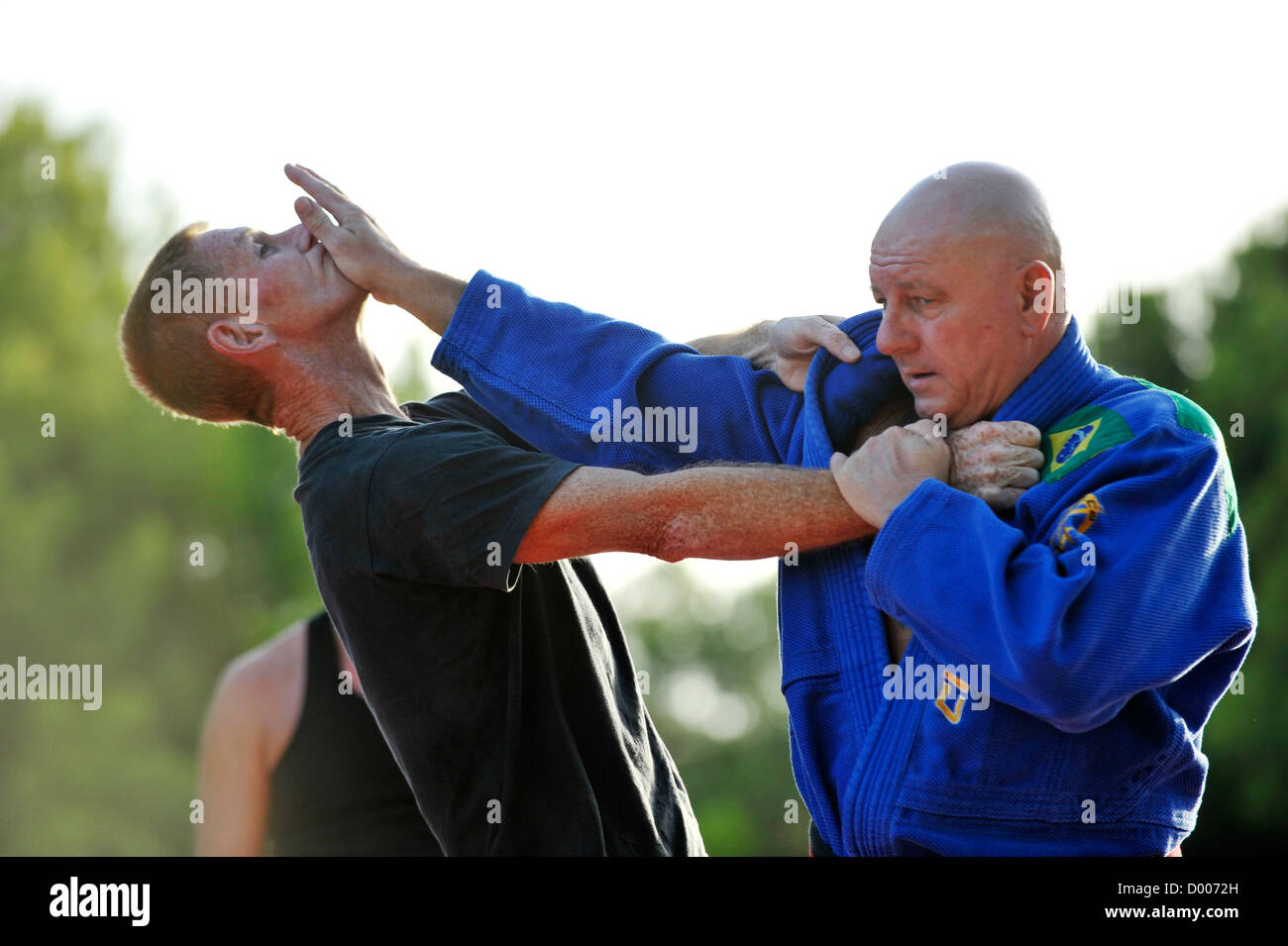 martial arts teacher demonstrates selfdefense grip on male student