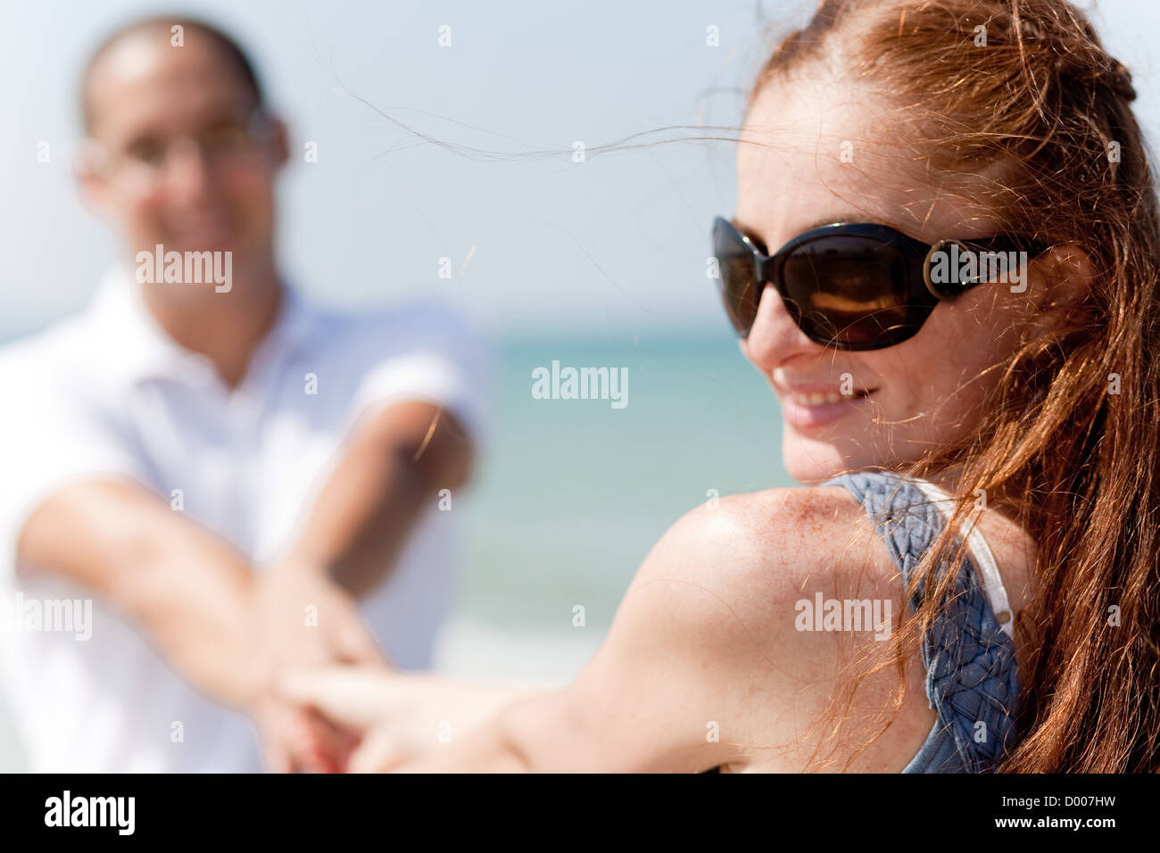 Rear view of young couple sitting at the beach,focusing on woman Stock ...