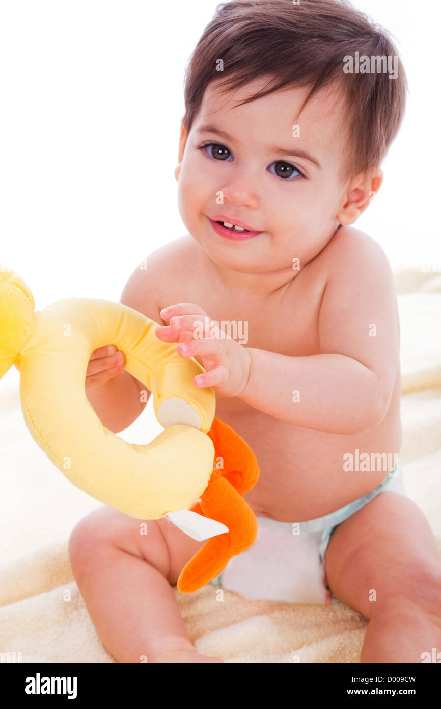 Baby play with doll and looking to the camera on a light background Stock Photo
