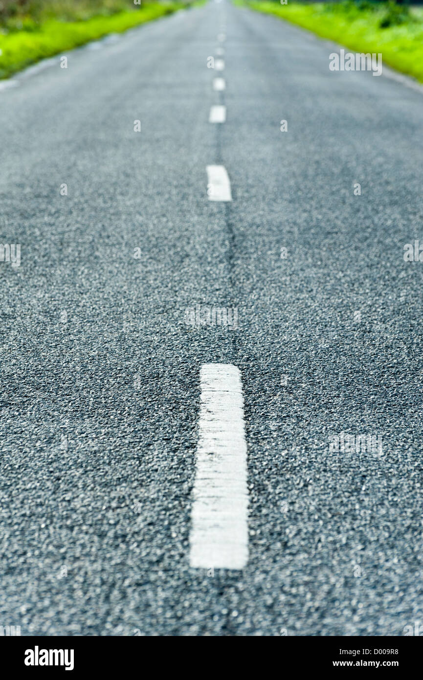 Amn empty straight road with white lines leading to a vanishing point on the horizon in the Fens UK Stock Photo