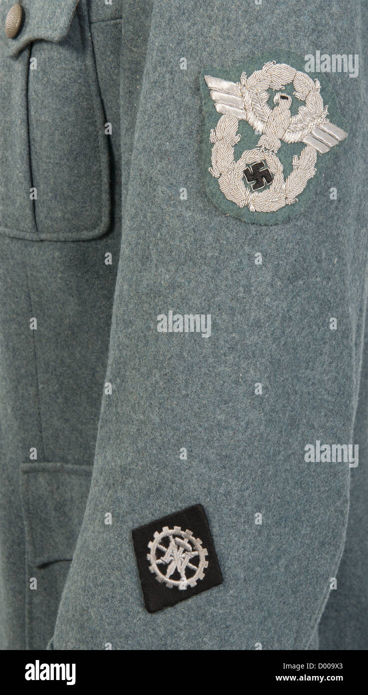 A field tunic for a 'Zugführer' of Technical Emergency Service,of police green woolen cloth,the hip pockets with double folds,field grey buttons,TeNo acceptance stamping and size stamp '46' inside green silk liner.Black collar tabs with continuous silver braid and insignia of rank on each side,looped shoulder boards and liner shot through with black,silver-embroidered police sleeve eagle,machine-embroidered traditional TeNo sleeve lozenge.Very rare field tunic with insignia introduced by Himmler in 1944 so as to standardise rank insignia of the,Additional-Rights-Clearences-Not Available Stock Photo
