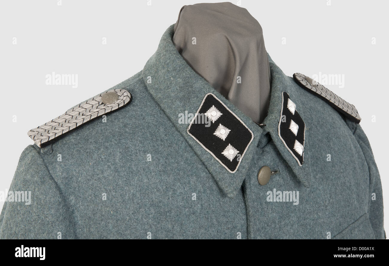 A field tunic for a 'Zugführer' of Technical Emergency Service,of police green woolen cloth,the hip pockets with double folds,field grey buttons,TeNo acceptance stamping and size stamp '46' inside green silk liner.Black collar tabs with continuous silver braid and insignia of rank on each side,looped shoulder boards and liner shot through with black,silver-embroidered police sleeve eagle,machine-embroidered traditional TeNo sleeve lozenge.Very rare field tunic with insignia introduced by Himmler in 1944 so as to standardise rank insignia of the,Additional-Rights-Clearences-Not Available Stock Photo