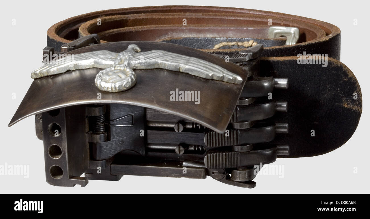 A "German SS Belt Buckle Gun",cal..22 l.r,no.4/c.Matching numbers.Four barrels,length 43 mm.Wehrmacht eagle on hinged lid,at the bottom two-line inscription: "BLN.- 44 - SS / R.V.F.Z.Nr.4/c".Patinated,spotted finish.Dimensions without belt loops approx.110 x 55 x 43 mm.Very good,fully functioning condition.Extremely rare.Operational sequence: When left-sided upper and lower ribbed levers are pressed simultaneously,the hinged lid and barrels spring open.Shots are released by pressing the now accessible ribbed triggers on the left.Simultane,Additional-Rights-Clearences-Not Available Stock Photo