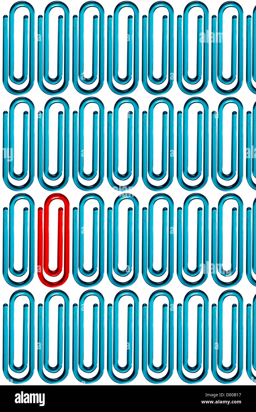 Red paper clip standing out from the crowd of blue paper clips over white background Stock Photo