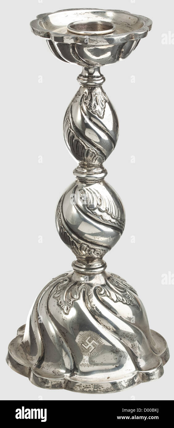 Hermann Göring - a silver candlestick in baroque style,Flaring bell-shaped base,the stem divided by three balusterss and decorated with foliage in relief work,large drip basin.On the viewing side an engraved emblem above 'Reichs-Luftschutzbund',on the reverse side engraved date '12.1.1940'.Silver hallmark '830' and master's mark.Height 35 cm.Weight 685 g.A gift of the RLB on occasion of Göring's 47th birthday in 1940.Provenance: 'Freiwillige Versteigerung aus dem ehemaligen Besitz von Hermann Göring im Namen und für Rechnung des Freistaates Bayern',N,Additional-Rights-Clearences-Not Available Stock Photo