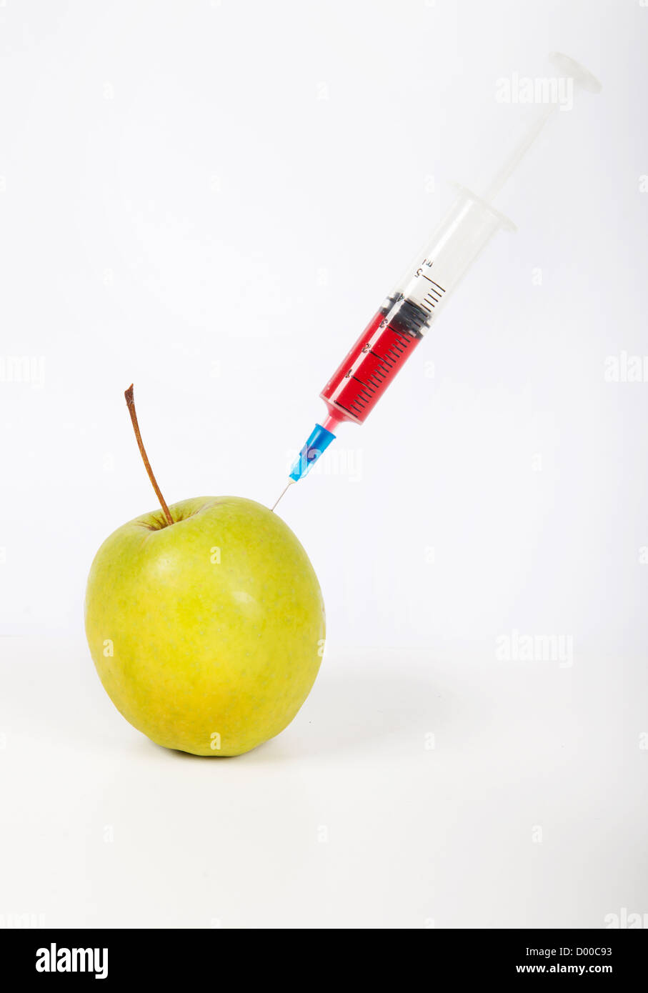 Granny smith apple being injected over white background Stock Photo
