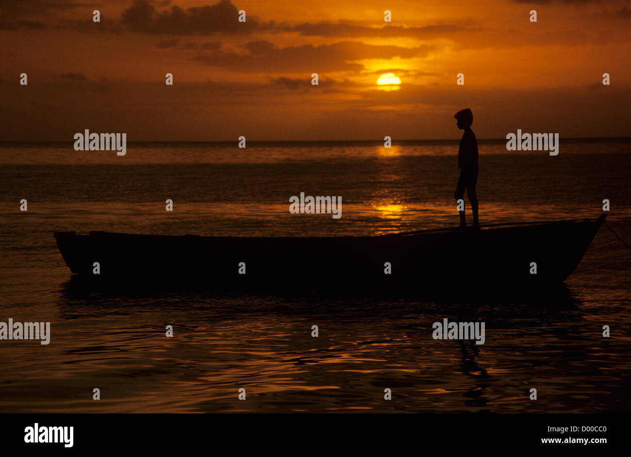 Young boy on boat at sunset, Fiji. Stock Photo
