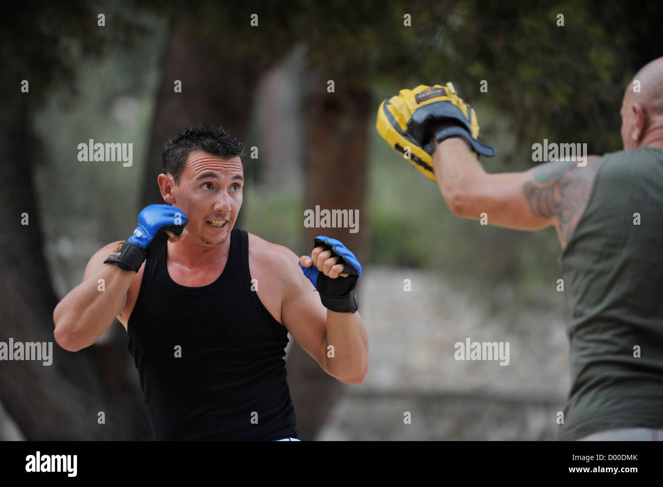 two men practice martial arts in a park Stock Photo