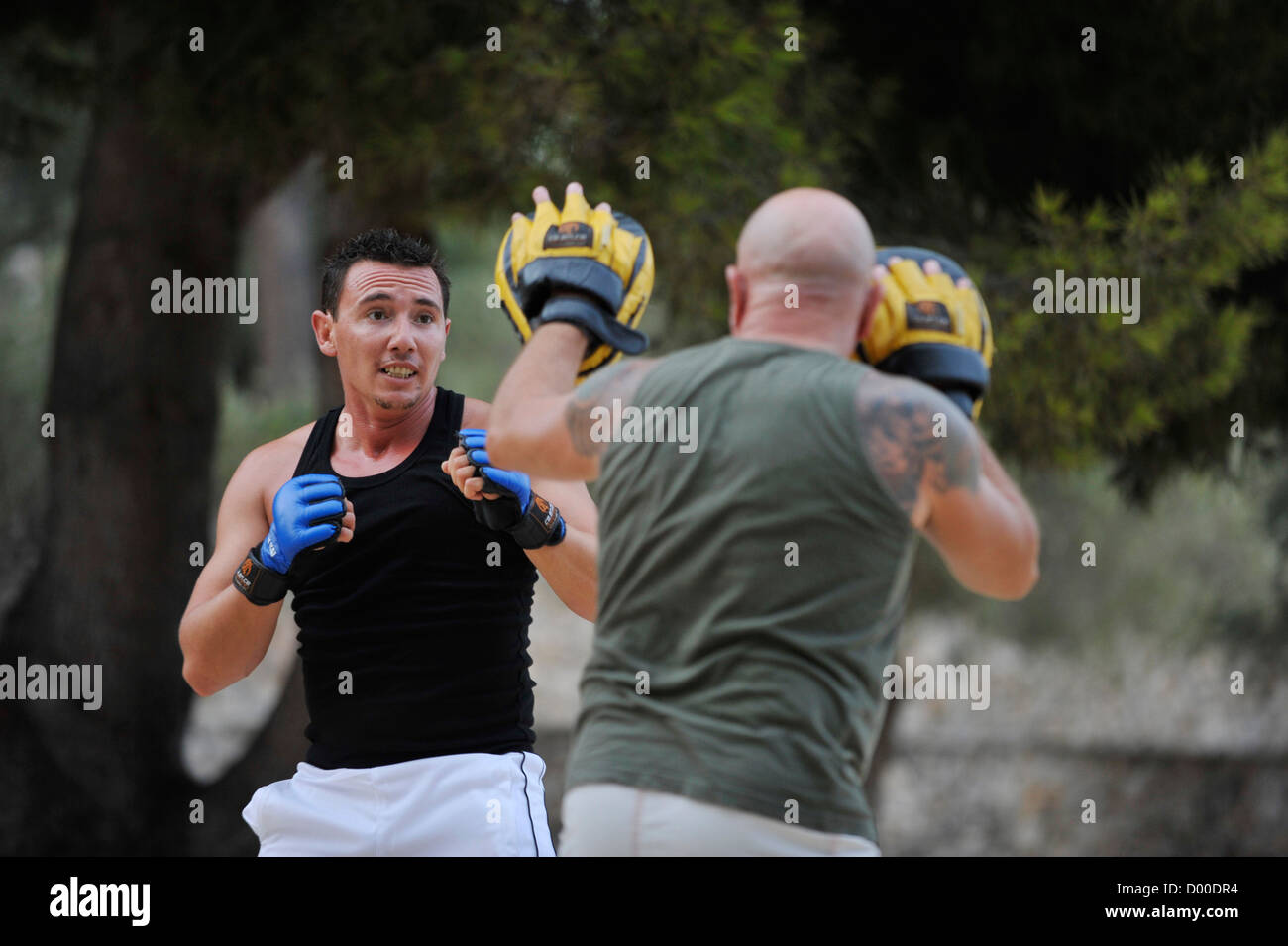 two men practice martial arts in a park Stock Photo